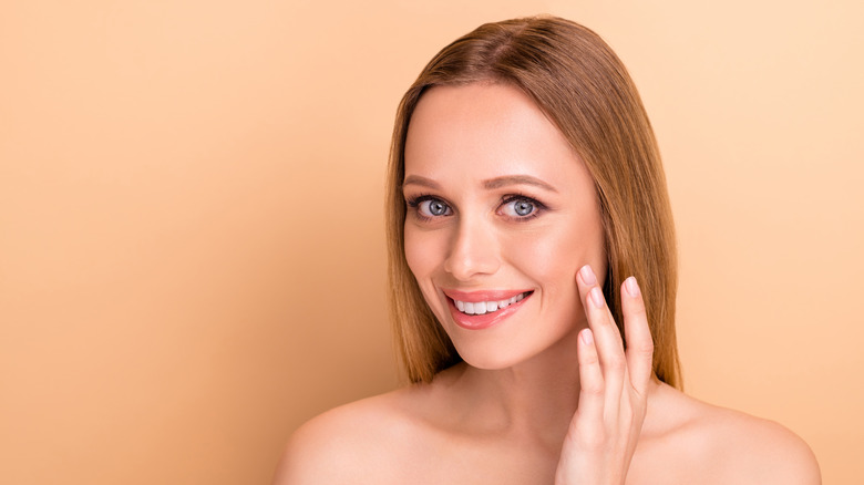 A woman happily touching her face
