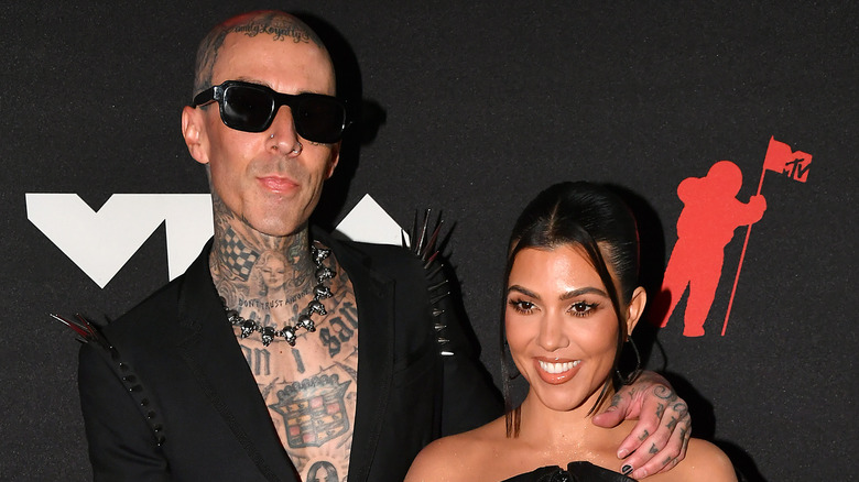 Travis Barker and Kourtney Kardashian both posing