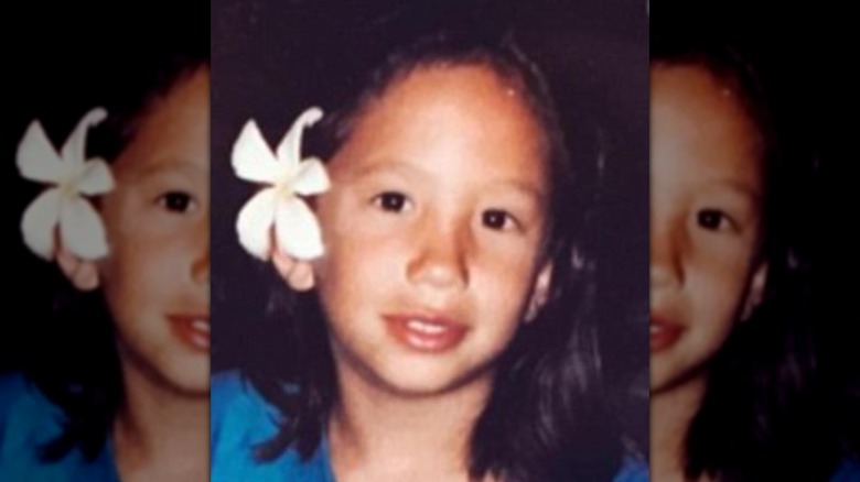 Cheryl Burke as a young girl with a flower in her hair