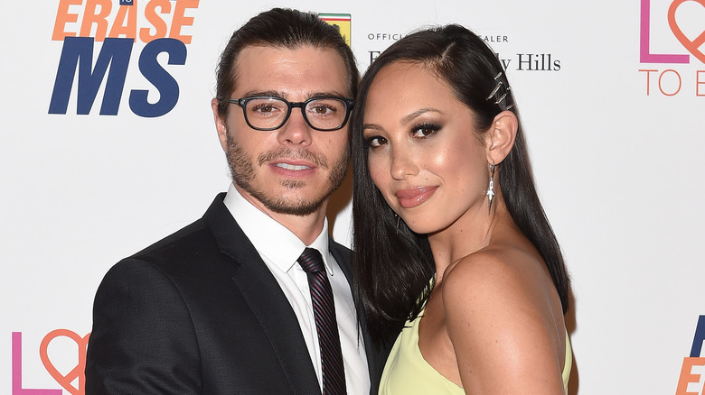 Cheryl Burke and Matthew Lawrence posing on step-and-repeat