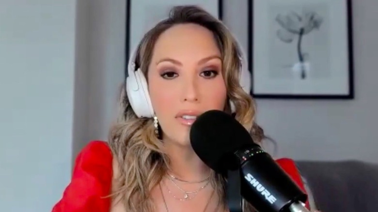 Cheryl Burke behind a microphone while recording a podcast