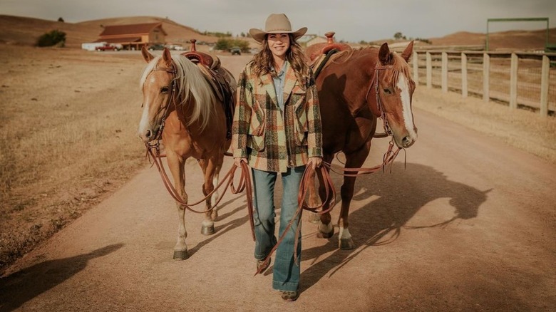 Kristi Noem walking two horses