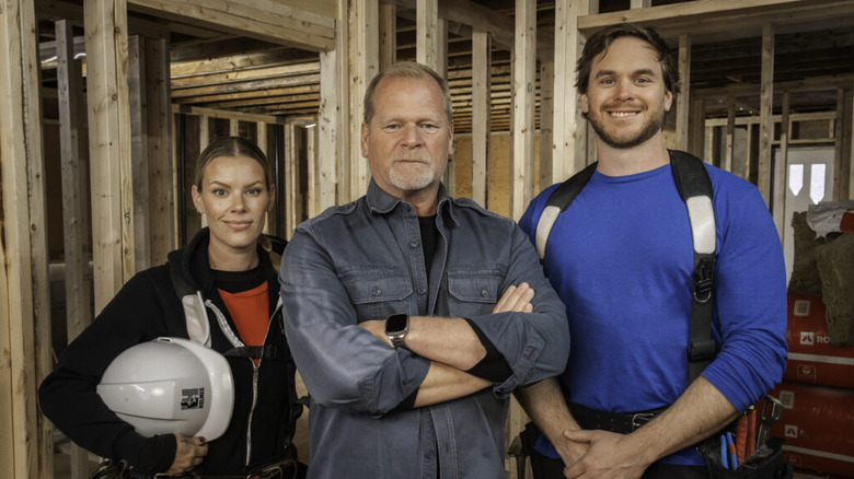 Mike Holmes posing with kids Sherry and Mike Jr. in the frame of an unbuilt house