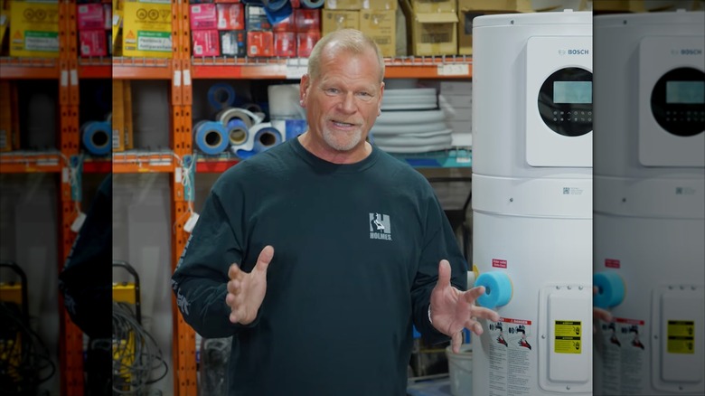 Mike Holmes talking in front of a water heater