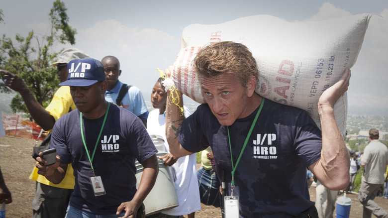 Sean Penn carrying a bag of food in Haiti in