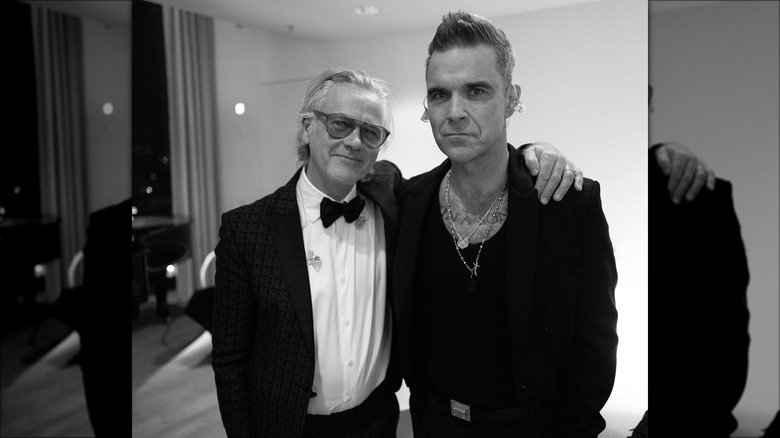Robbie Williams and Guy Chambers posing for photos