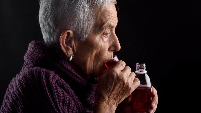 Elderly woman drinking medicine