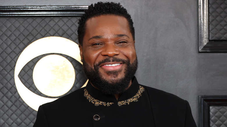 Malcolm-Jamal Warner smiling on step-and-repeat