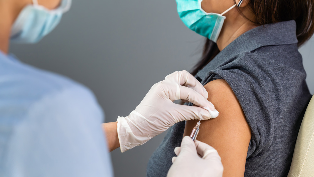 Healthcare worker giving a person COVID-19 vaccine 