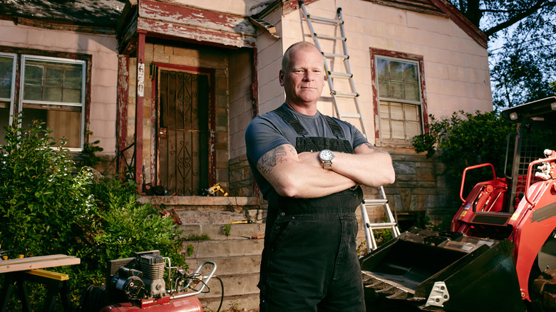 Mike Holmes standing in front of a house
