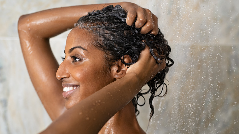 A woman washing her hair in the shower. 