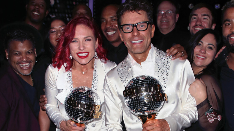 Season 18 winners Bobby Bones and Sharna Burgess holding Mirrorball trophies