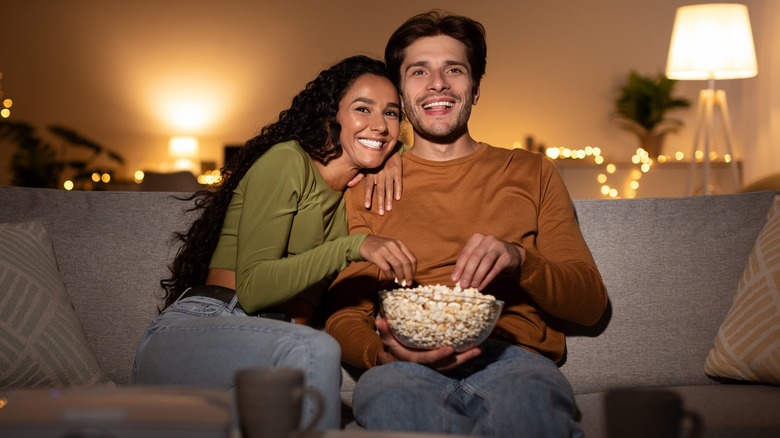 couple cuddling while watching movie 