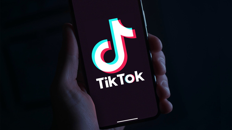 Image of hand holding phone with TIkTok app open