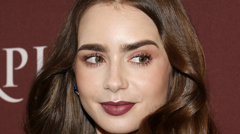 Lily Collins poses at an event