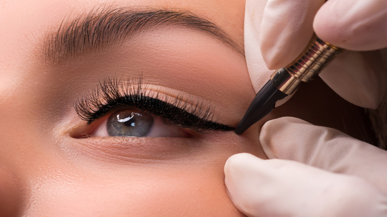 A woman getting eyeliner applied to her face