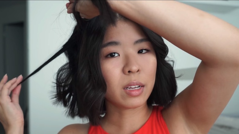 Letitia Kiu pulling on hair curl to loosen it