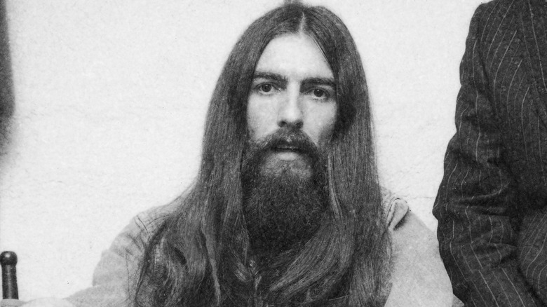 British popular rock and roll guitarist and singer George Harrison (1943 - 2001), formerly of the Beatles, sits for a photo during a party, 1971.