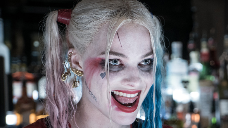 Margot Robbie's Harley Quinn grinning at a bar