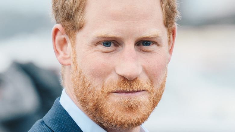 Prince Harry grimacing while wearing a suit 