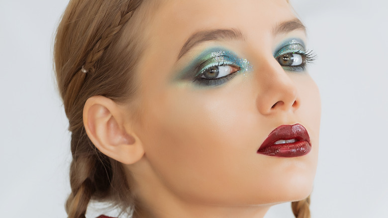 Woman with dramatic eyeshadow and a bold lip.