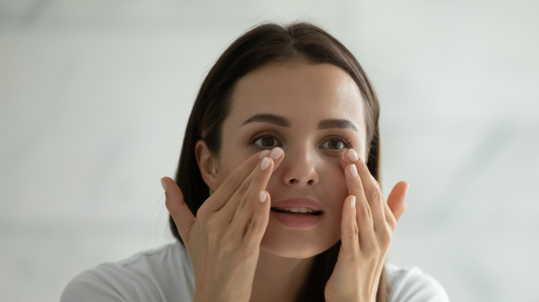 Woman rubbing under her eyes