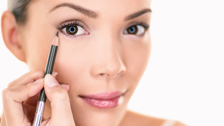 Woman applying eyeliner