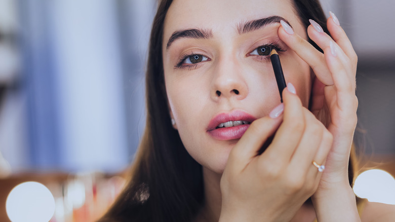 Woman applying eyeliner