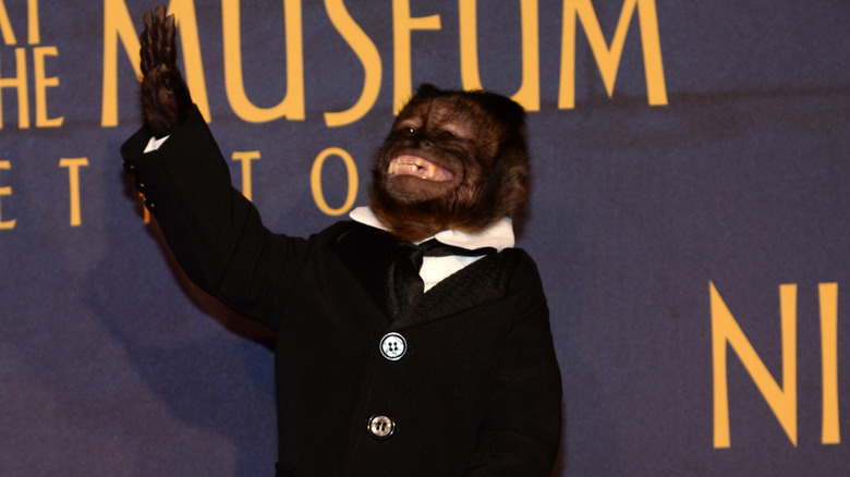 Crystal the monkey wearing a tuxedo while smiling and waving