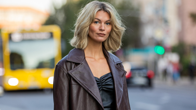 person in brown coat and black dress at About You Fashion Week in Berlin, Germany