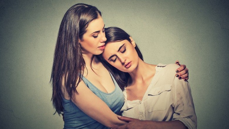 Young woman consoling another young woman