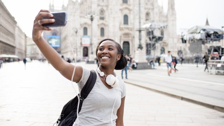 Woman smiling and taking a selfie in front of a giant church