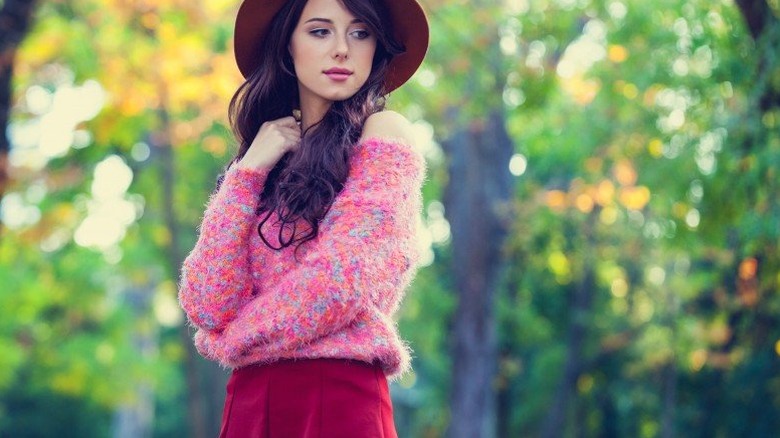 Young woman looking thoughtful against a backdrop of trees