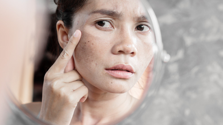 A woman checking for bags under her eyes