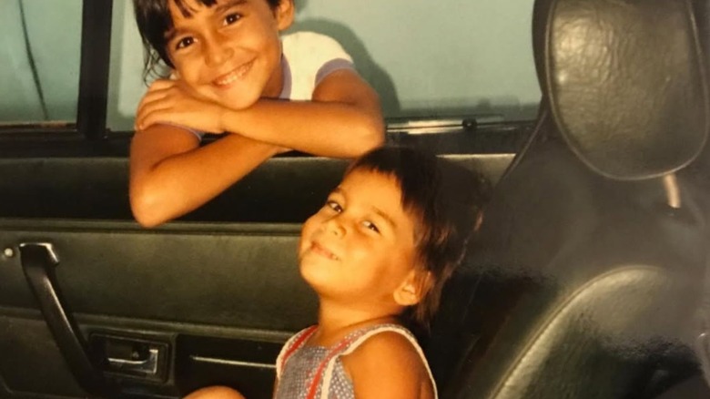 Tulsi Gabbard as a kid leaning out of the car window, her sister Vrindavan in the back seat