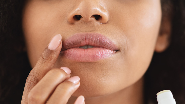 Applying lip balm with fingers 