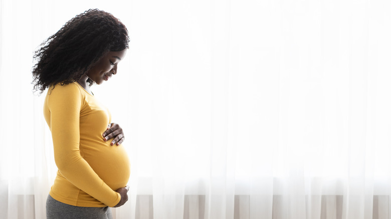 Pregnant woman in yellow sweater 