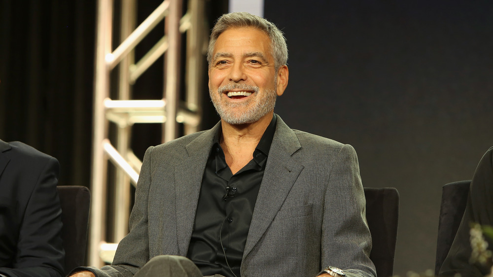 George Clooney smiling in a chair