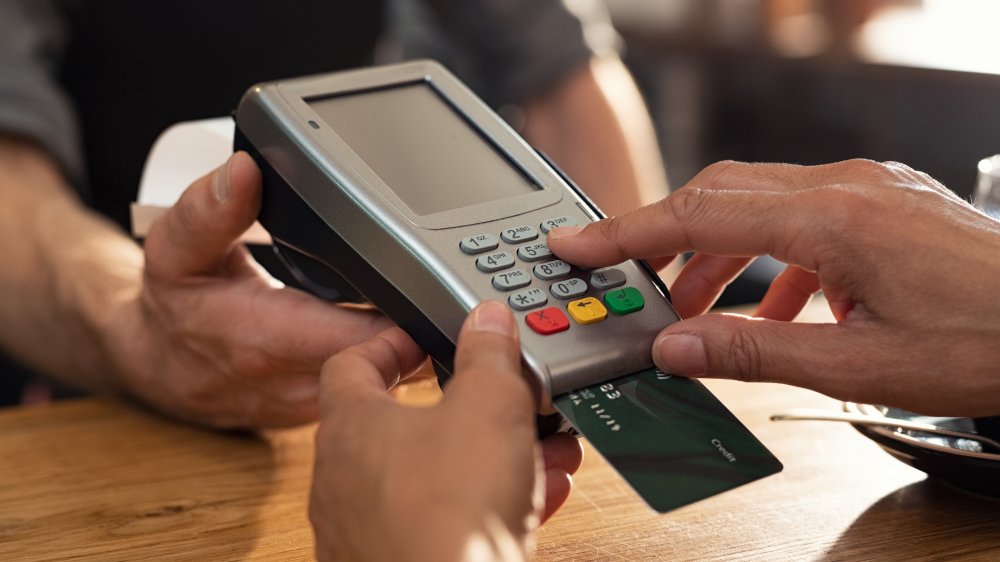 Hand touching credit card machine