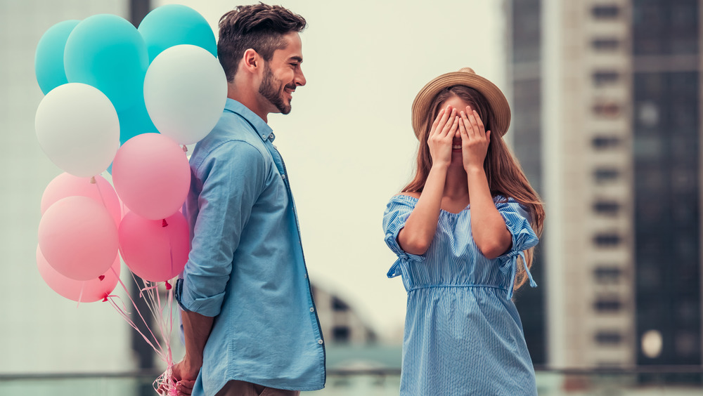 Man with balloons surprises woman