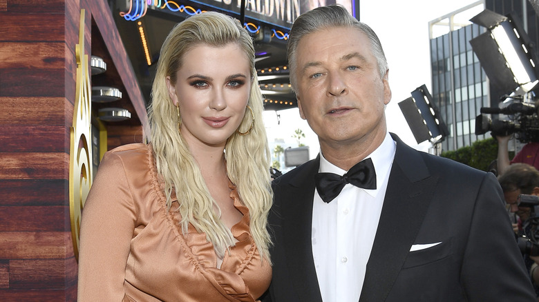 Ireland Baldwin wearing orange and Alec Baldwin wearing a tuxedo