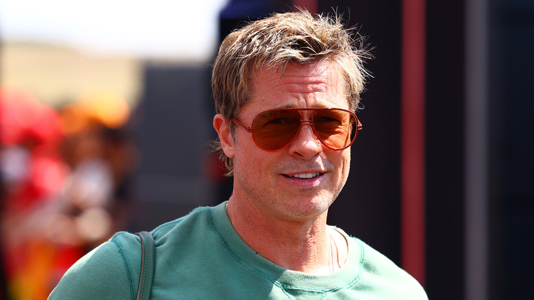 Brad Pitt smiles and wears sunglasses