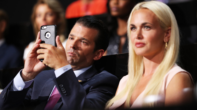 Donald Trump Jr. looking at his phone with Vanessa Trump sitting beside him