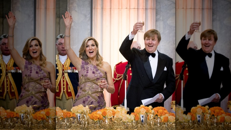 Queen Máxima and King Willem-Alexander cheering and raising drinks and arms at royal dinner