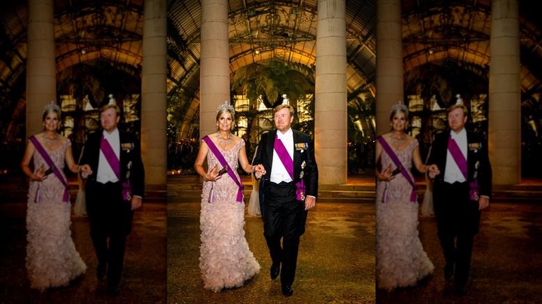 Queen Máxima and King Willem-Alexander walking in formal attire through grand building