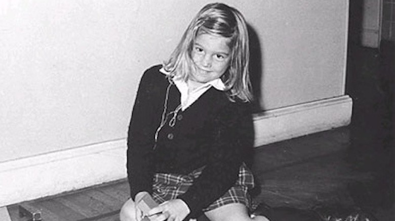 A young Queen Máxima sits smiling in her school uniform.
