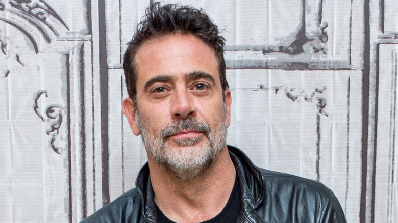 Jeffrey Dean Morgan slightly smiling while posing at an event in a leather jacket