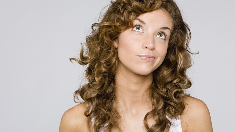 woman with curly hair questioning