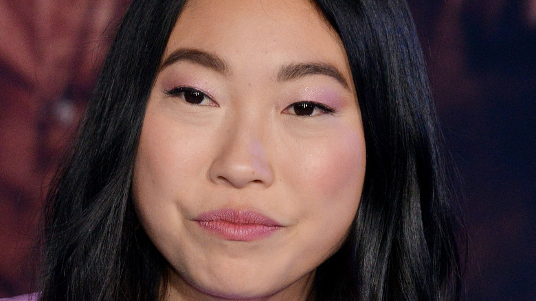 Awkwafina in purple on a red carpet