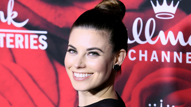 Meghan Ory smiling  while posing at a Hallmark event